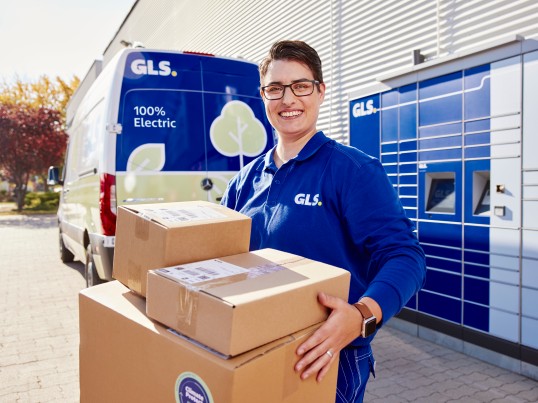 Zustellerin-stellt-Pakete-in-Paketbox-zu