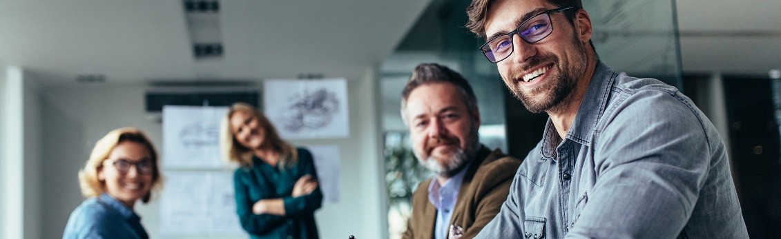 Vier Menschen sitzen in einem Meeting zusammen