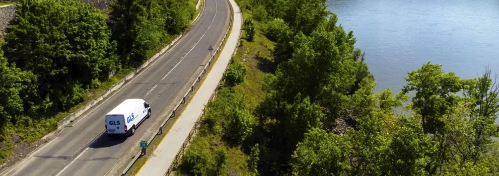 Sähköinen jakeluauto ajaa luonnon keskellä