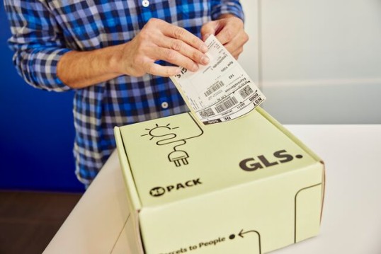 Employé GLS étiquetant un colis avant sa réexpédition, illustrant le travail de l’Excellence Lab pour identifier et renvoyer les colis perdus à la bonne adresse