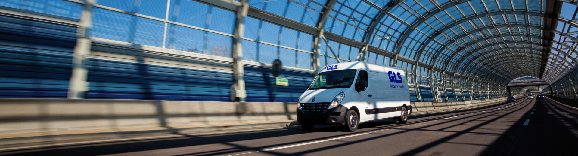 GLS parcel delivery van driving through a glass tunnel